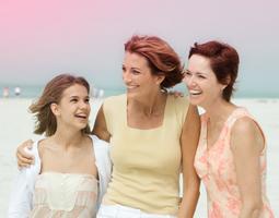 Bild på 3 kvinnor som håller om varandra, en yngre kvinna till vänster och två äldre kvinnor till höger
